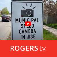 Sign stating Municipal Speed Camera in Use with RogersTV and the youtube symbol in the middle